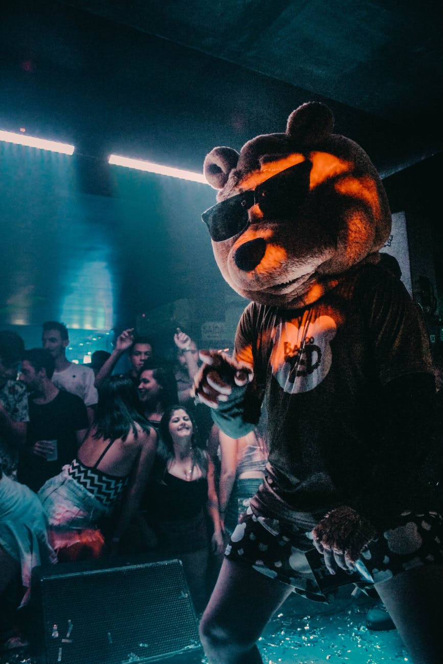 person wearing bear mask dancing on stage